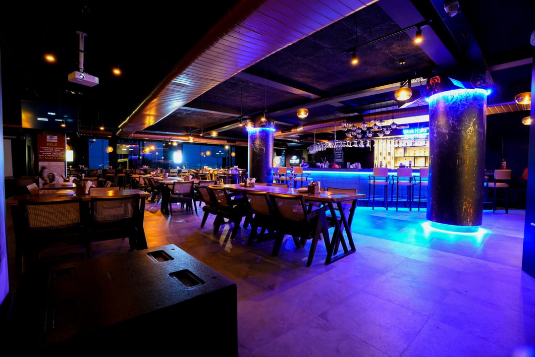 Ambient dining floor with blue-lit pillar and bar