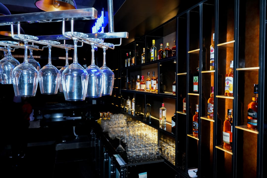 Backlit spirit shelving and hanging glassware at the bar