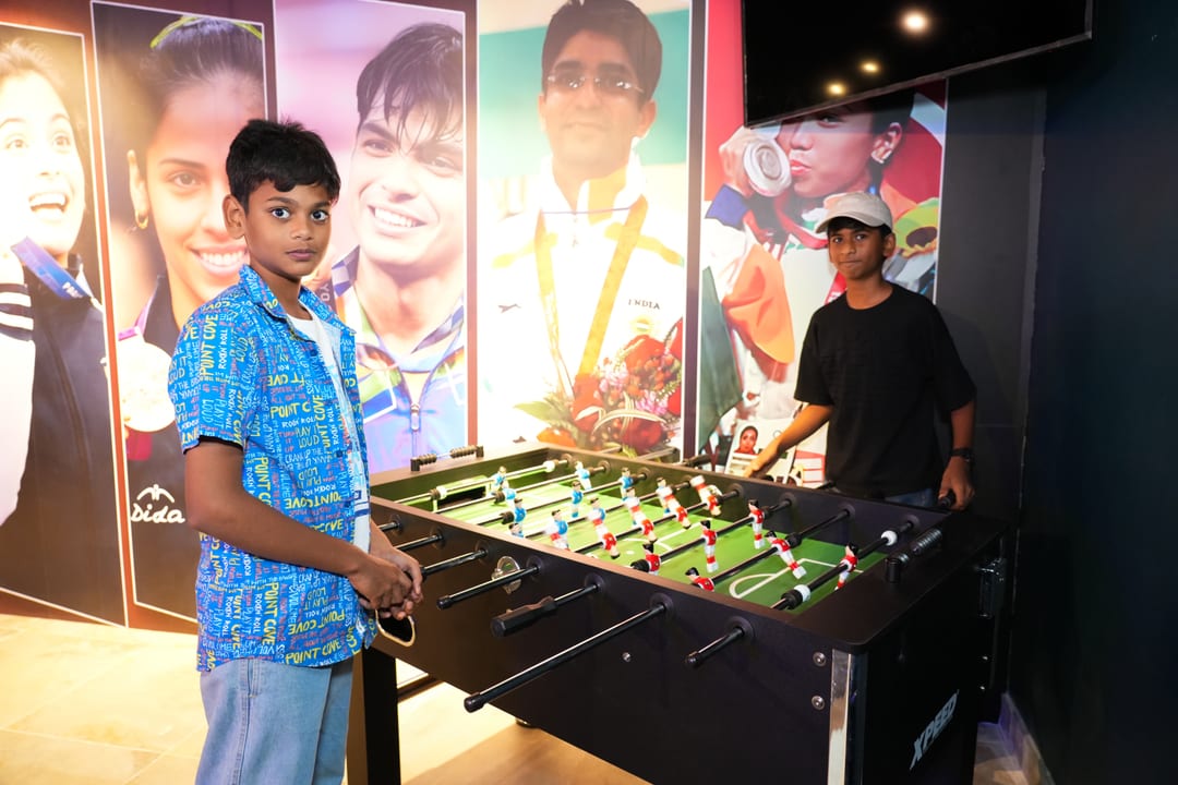 Two guests playing foosball beside the sports legends wall