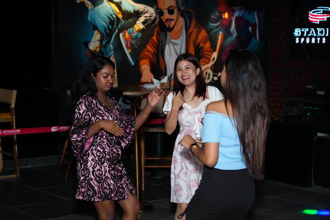 Guests dancing and laughing near the mural wall