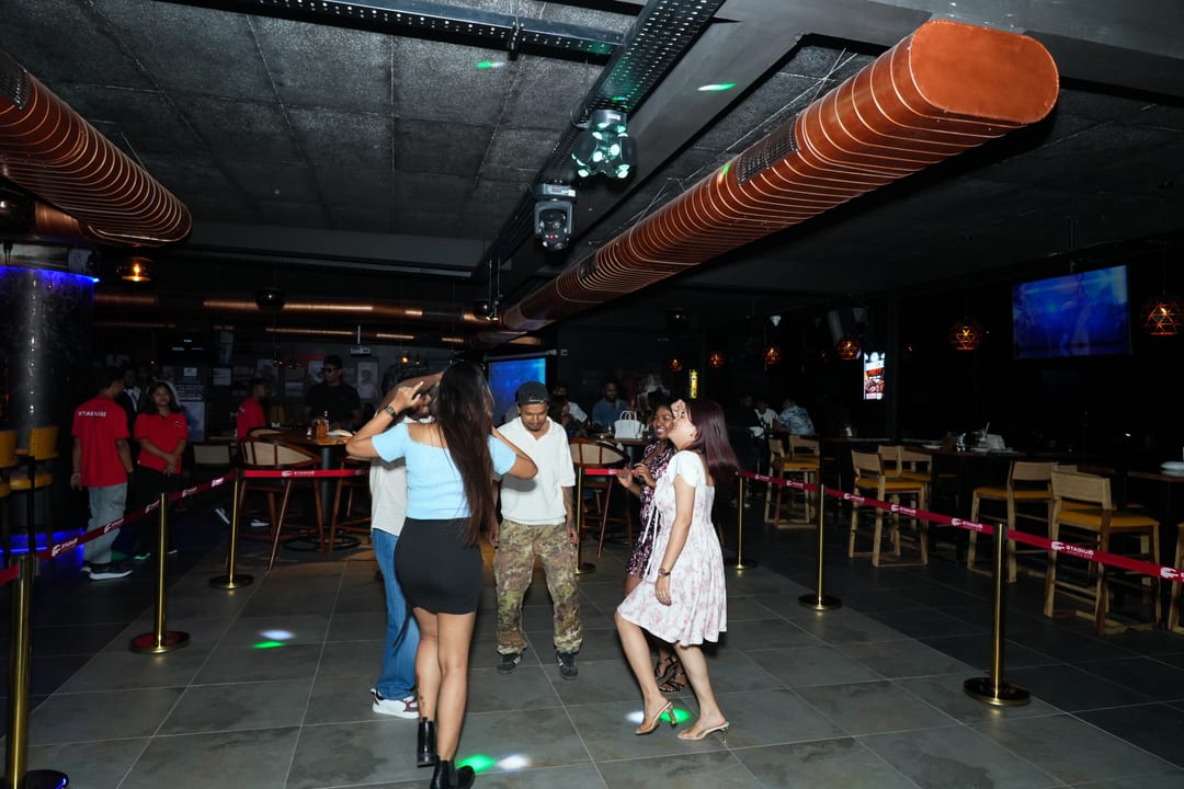 Guests dancing on the floor beneath the copper duct ceiling