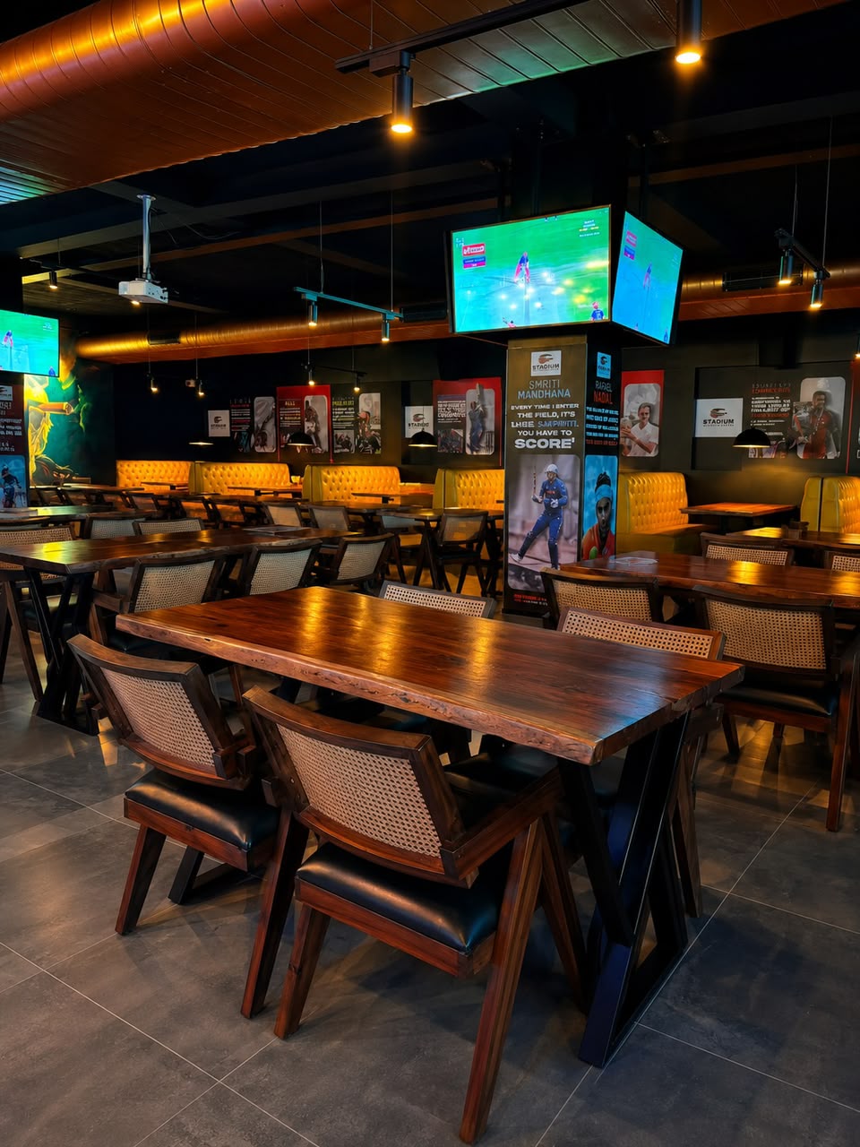 Cane-back chairs and wooden tables under warm pendant lighting